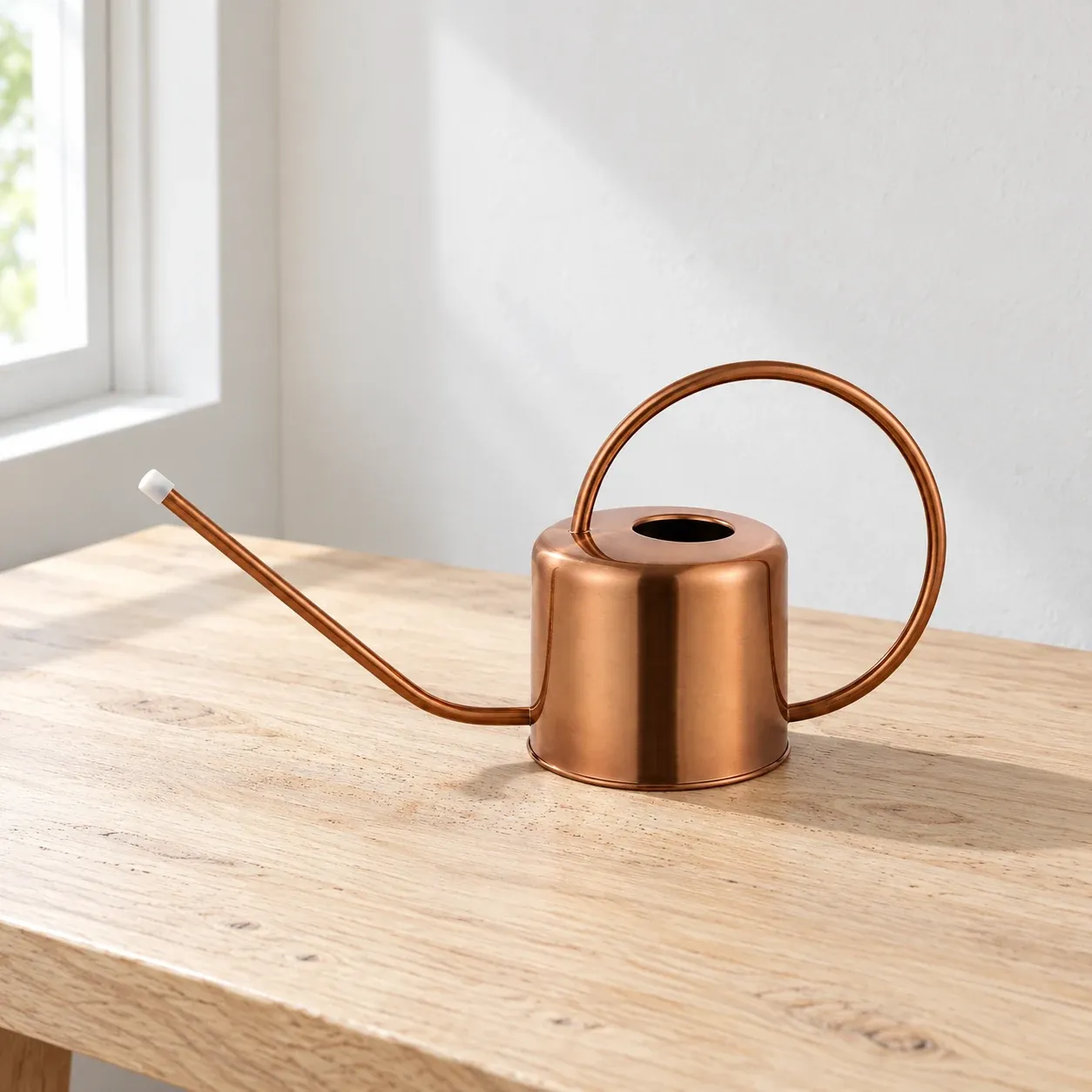 Copper-tone watering can with a long spout and round handle